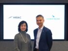 Two people standing together with HKBAC and Cathay Pacific logos displayed behind them.