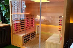  Infrared sauna at the Raw Lilly event, featuring a glass door and a warm wooden floor