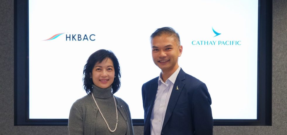 Two people standing together with HKBAC and Cathay Pacific logos displayed behind them.